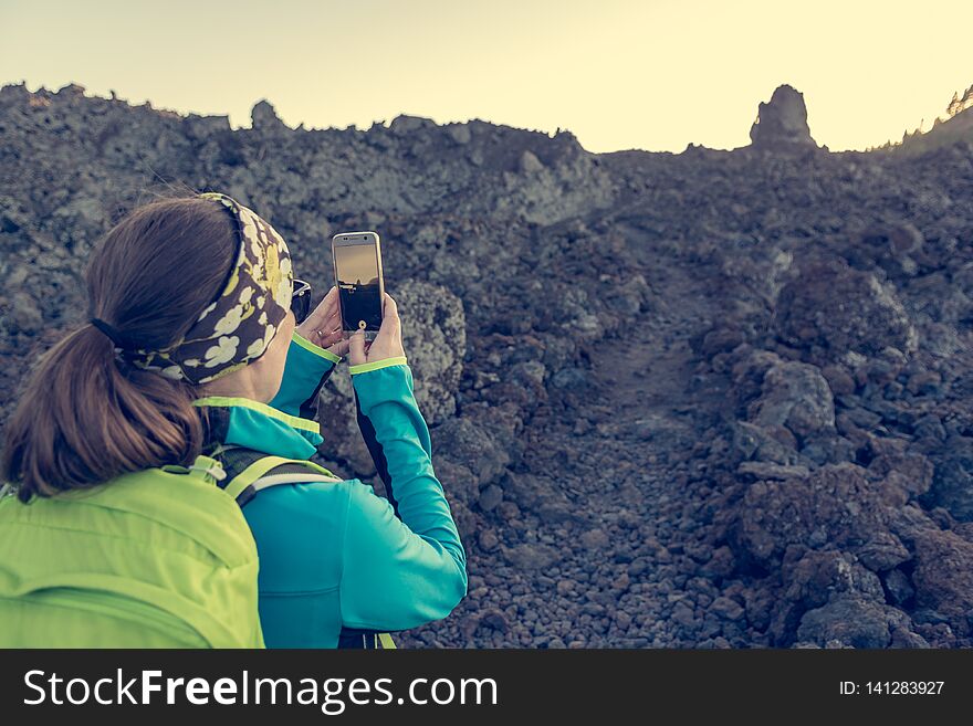 Female hiker taking phots of spectacular volcanic landscape. Chinyero trek, Spain.