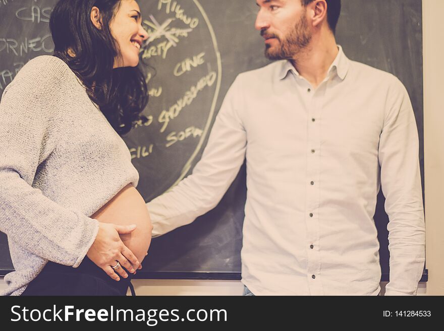 Nice caucasian couple at home touching the belly and waiting for the new baby coming. pregnant concept for new mother and father.