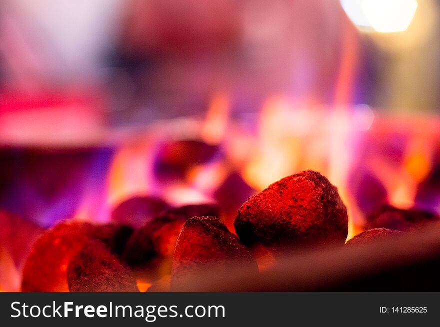 Flaming coals hot rocks with multicolored flames for barbeque