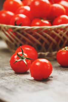 Fresh Red Tomatoes In A Wicker Basket On An Old Wooden Table. Ripe And Juicy Cherry Tomatoes With Drops Of Moisture, Gray Wooden Stock Photography Fresh Red Tomatoes In A Wicker Basket On An Old Wooden Table. Ripe And Juicy Cherry Tomatoes With Drops Of Moisture, Gray Wooden Stock Photography