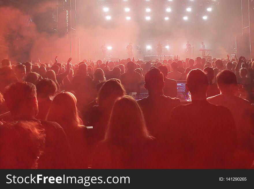 Crowd of people with raised hands in night club