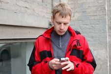 Blond Man In Red Jacket Talk On Mobile Phone. Royalty Free Stock Photo