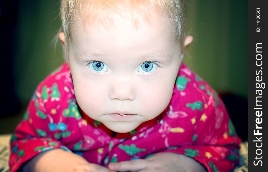 Beautiful little baby with blond hair and blue eyes.