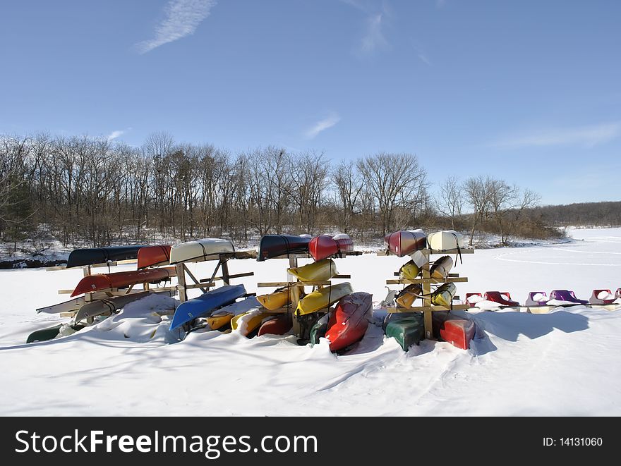 Multi-colored canoes in the winter, blue skies