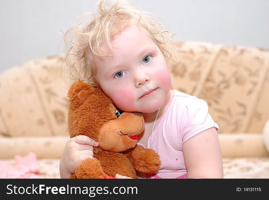 Pretty curly blond hair girl embrace with toy bear. Pretty curly blond hair girl embrace with toy bear.