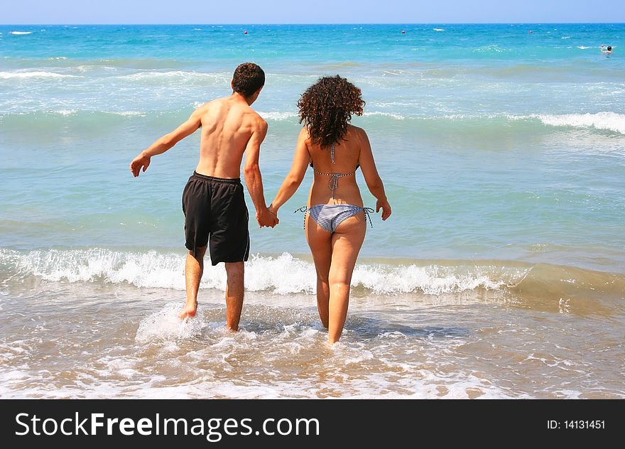 Couple walking to the sea.