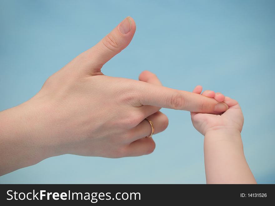 The baby has grasped a finger of mum. The baby has grasped a finger of mum