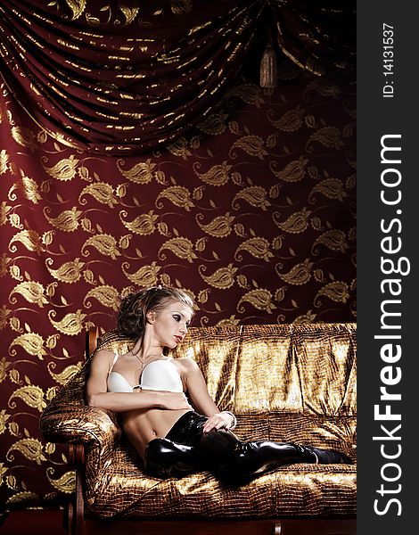 The beautiful girl in underwear on a gold sofa. The beautiful girl in underwear on a gold sofa