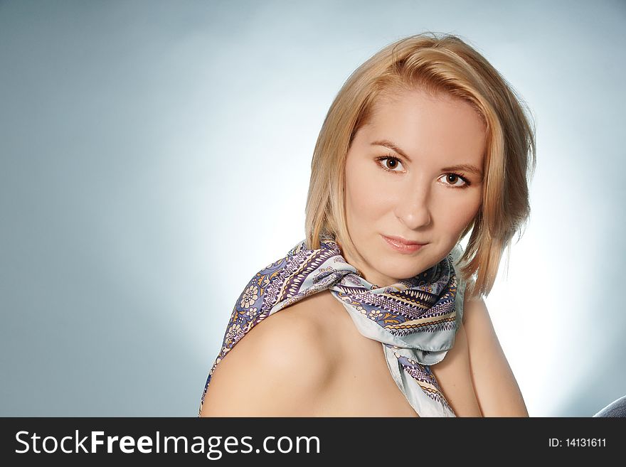 Potrrait of young attractive woman in scarf on blue background