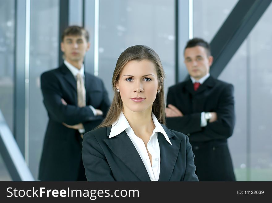 A young business woman in front of her colleagues in a modern office. A young business woman in front of her colleagues in a modern office.