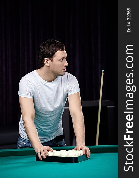 The young attractive man is going to play billiards. The young attractive man is going to play billiards