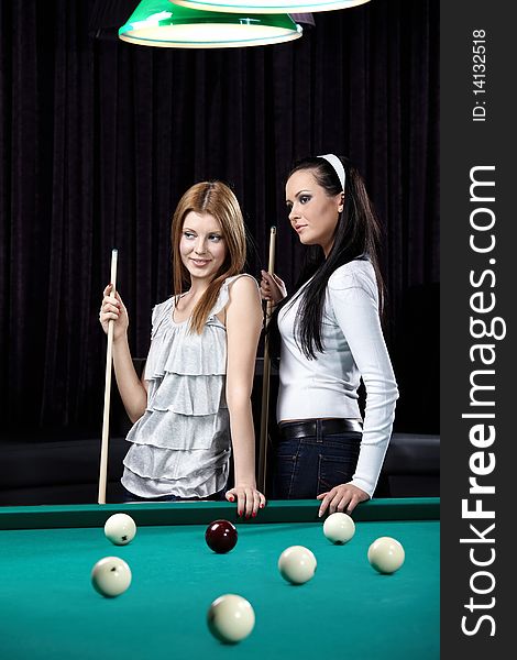 Two nice young girls at a billiard table. Two nice young girls at a billiard table
