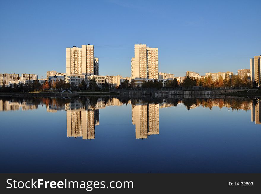 Modern buildings are reflected in a city pond. Modern buildings are reflected in a city pond.