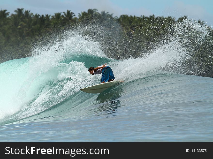 Surfer doing turn on tropical blue wave, mentawai Islands, Indonesia. Surfer doing turn on tropical blue wave, mentawai Islands, Indonesia