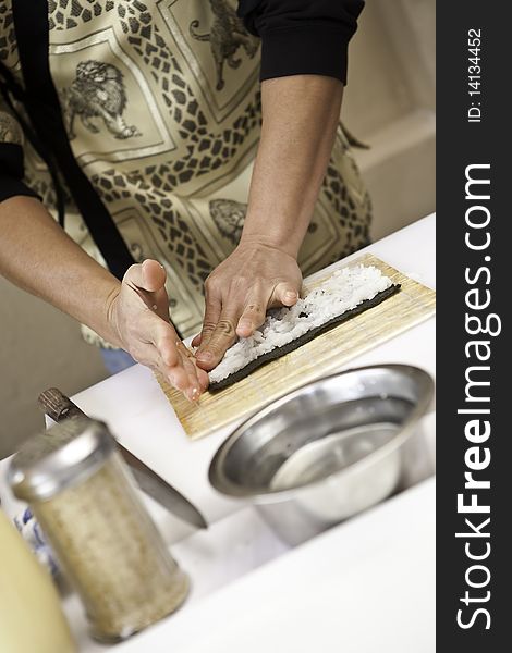 A sushi chef in action preparing a sushi dish