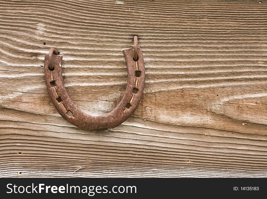 Rusty metal horseshoe on old board. Rusty metal horseshoe on old board