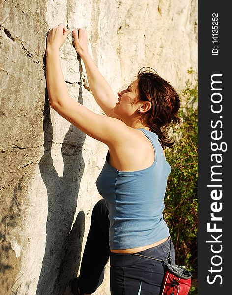 Young woman in search for holds while climbing. Young woman in search for holds while climbing