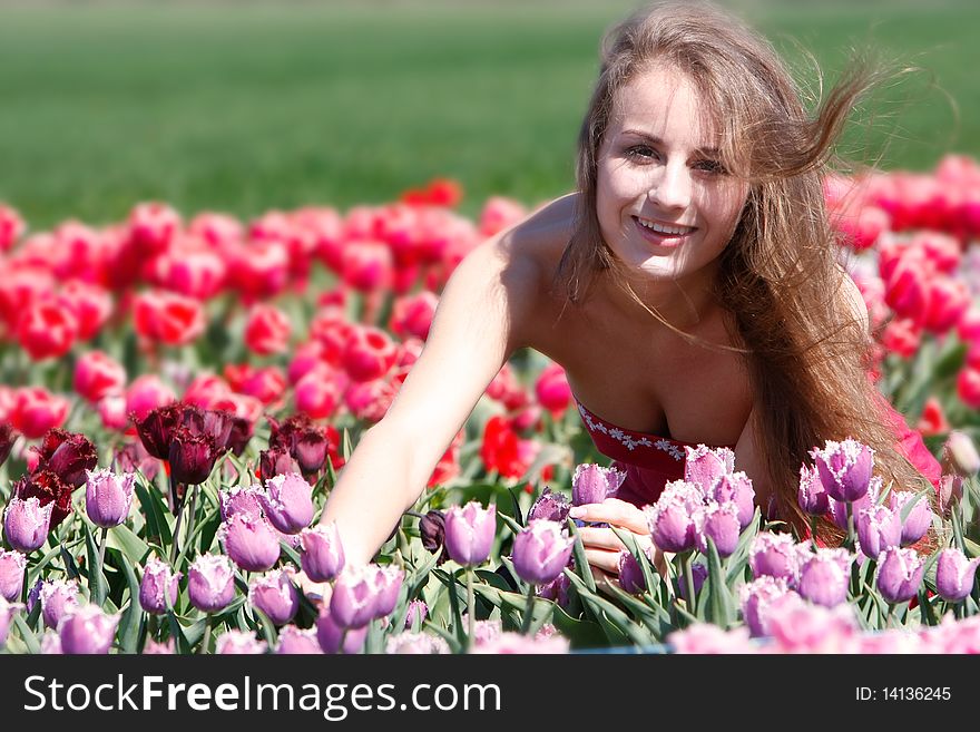 Happy girl in red and purple tulips