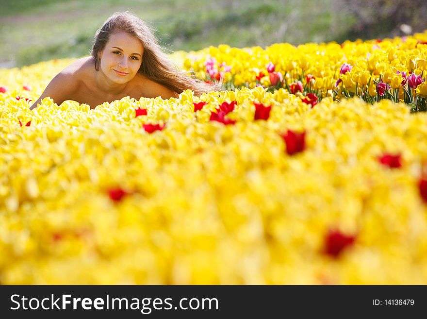 Young beautiful girl in yellow tulips