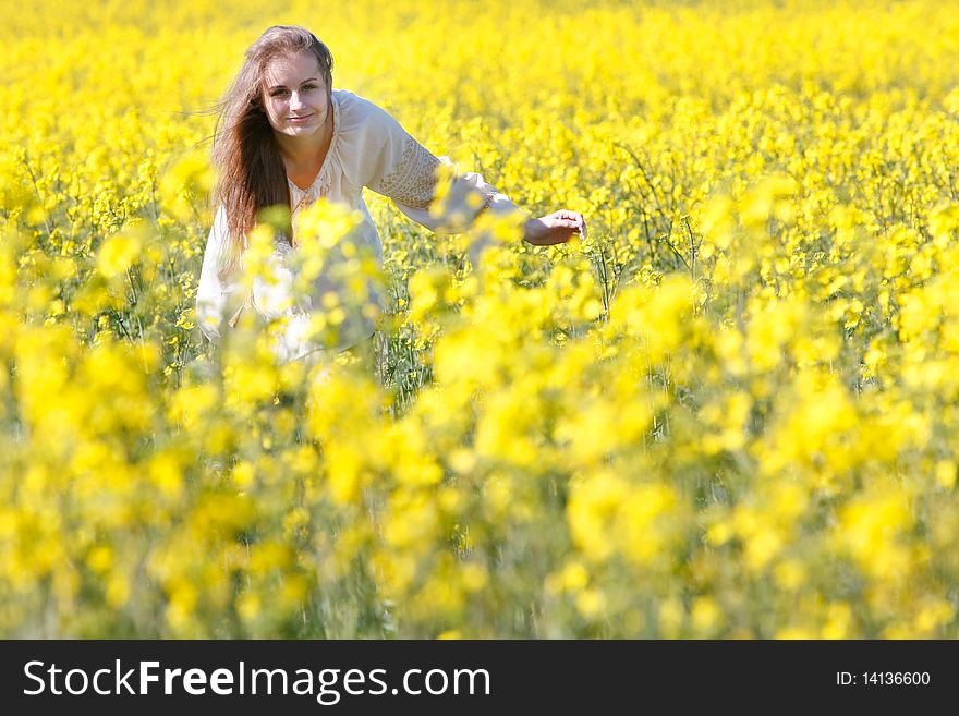 Young happy girl in yellow flowers