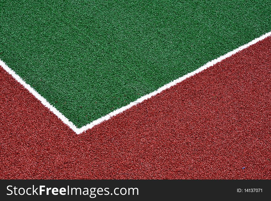 Red racetrack and green sports field with artificial grass. Red racetrack and green sports field with artificial grass