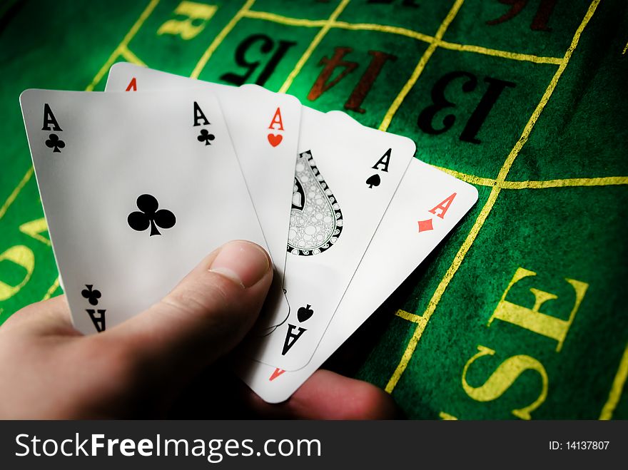 Poker of aces in man's hand on a gambling table. Poker of aces in man's hand on a gambling table.