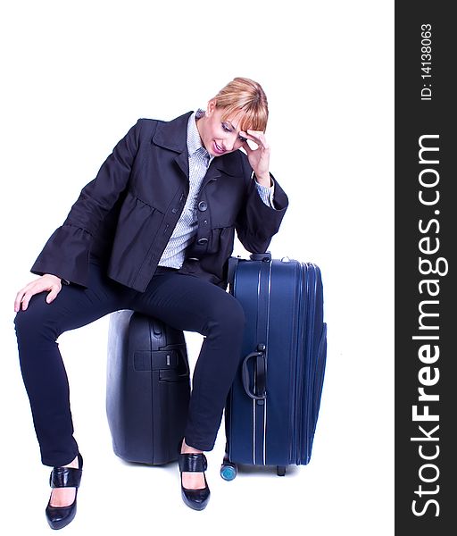 Young businesswoman sits on black suitcase and waiting for somebody, isolated on white