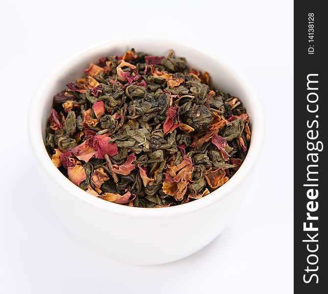 Bowl filled with dried green tea leaves and rose petals on white background. Bowl filled with dried green tea leaves and rose petals on white background