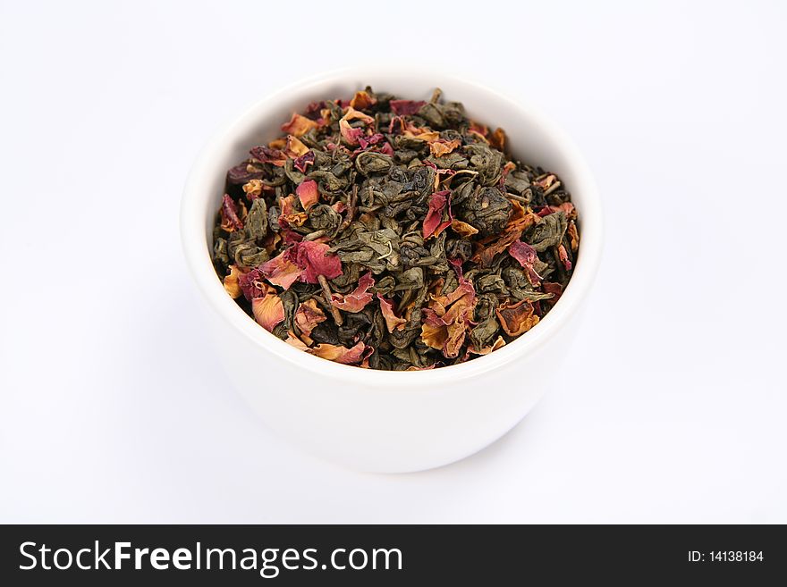 Bowl filled with dried green tea leaves and rose petals on white background. Bowl filled with dried green tea leaves and rose petals on white background