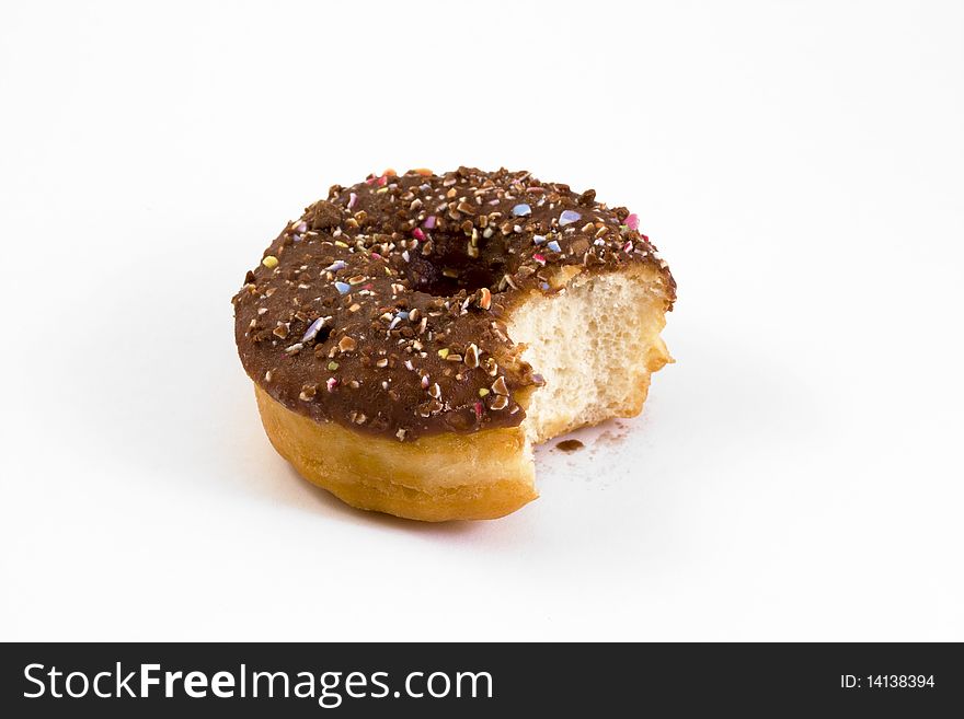 Chocolate covered doughnut with a bite taken out over white. Chocolate covered doughnut with a bite taken out over white