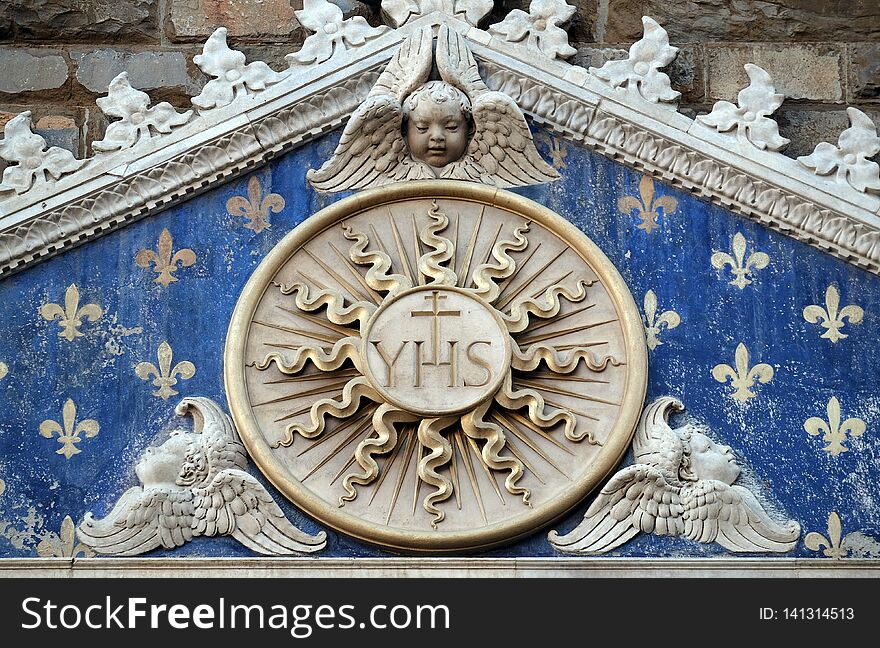 Medallion with the IHS monogram between two lions, above to the entrance to Palazzo Vecchio, a UNESCO World Heritage Site in Florence, Italy. Medallion with the IHS monogram between two lions, above to the entrance to Palazzo Vecchio, a UNESCO World Heritage Site in Florence, Italy