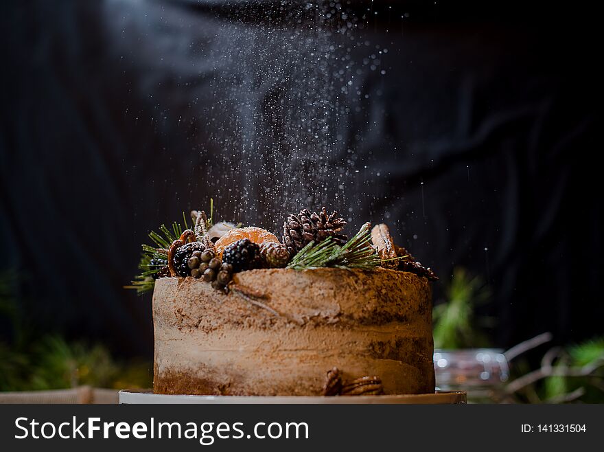 Cake with sugar in black background pines