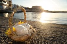 Small Basket With Two Easter Eggs On The Sea Doc On Golden Hour Royalty Free Stock Photography