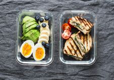 Two Healthy Office Lunch Box With Sweet And Savoury Food. Boiled Egg, Avocado, Tuna Spinach Cheese Sandwiches, Fruit On Grey Royalty Free Stock Images