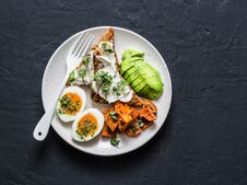Cream Cheese Toast, Avocado, Boiled Egg, Baked Sweet Potatoes - Delicious Healthy Breakfast Or Snack On A Dark Background Royalty Free Stock Image