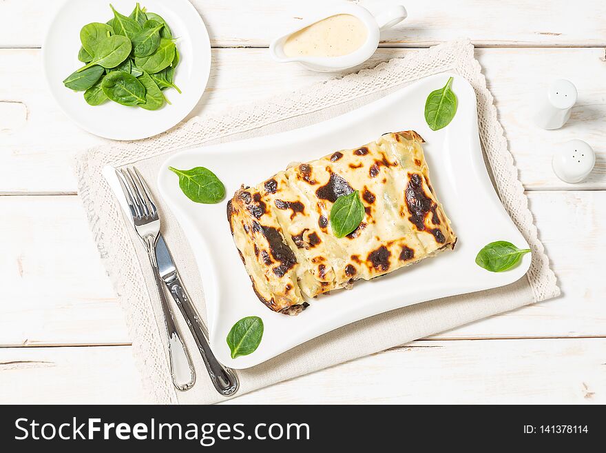 Serving cannelloni with beef minced and spinach baked in béchamel sauce. Serving cannelloni with beef minced and spinach baked in béchamel sauce