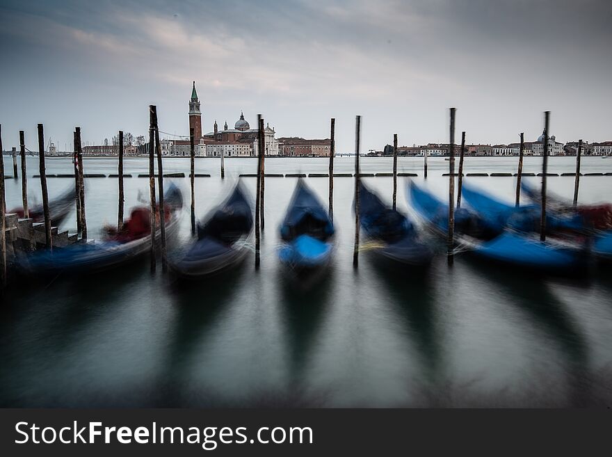 The dancing goldola`s accross from church of San Giorgio Maggiore at sunset. The dancing goldola`s accross from church of San Giorgio Maggiore at sunset