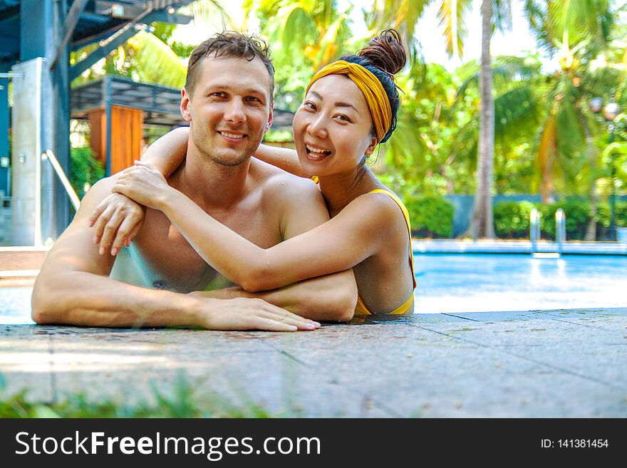 Photo Happy couple in the pool chatting with each other. Loving couple laugh around the pool at the hotel. Photo Happy couple in the pool chatting with each other. Loving couple laugh around the pool at the hotel.