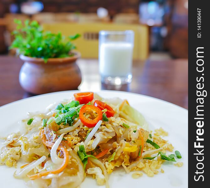 Closeup Of Chinese Food, Fried Noodle Mixed With Egg And Vegetables On White Plate