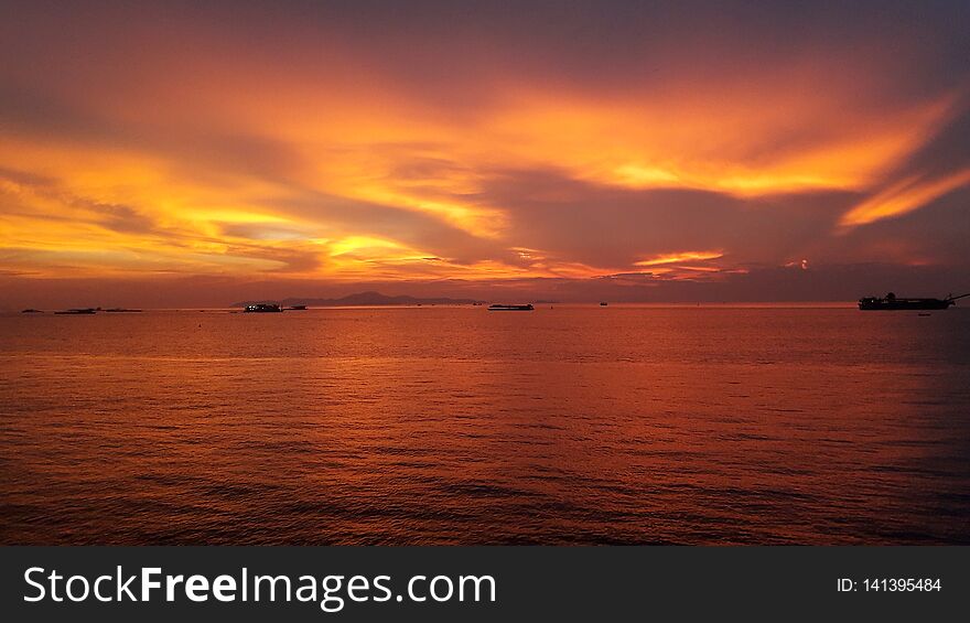 Orange sky during sunset in summer. Many boats& x27; floating on the calm sea.