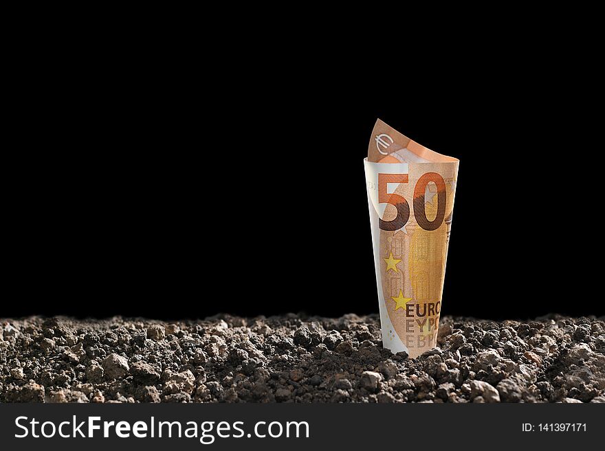 Image of EURO money banknote on top of soil for business, saving, growth, economic concept isolated on black background