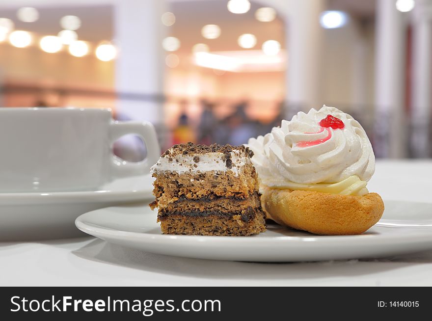 Pastry on a plate against the background of a coffee cup. Pastry on a plate against the background of a coffee cup.