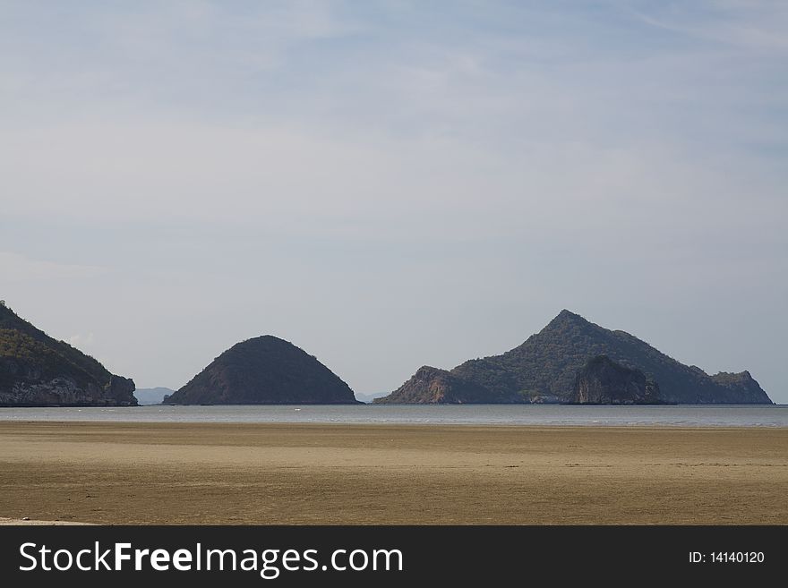 Golden beach and mountains with blue sky in the background. Golden beach and mountains with blue sky in the background.