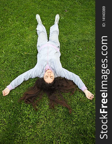 Young woman, lying on the fresh green grass, enjoying outdoors. Young woman, lying on the fresh green grass, enjoying outdoors