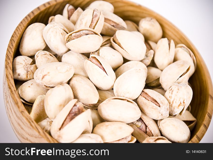 Many natural pistacios on brown bowl