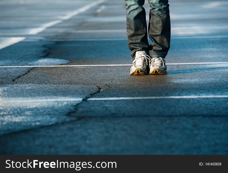 Human legs in sneakers standing on square. Human legs in sneakers standing on square