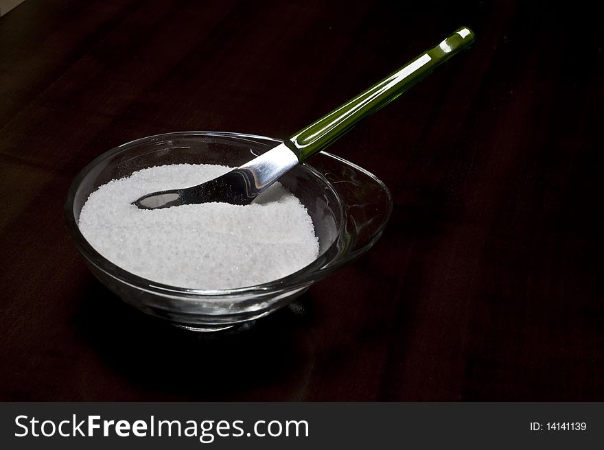 Full container of sugar on a wooden board. Full container of sugar on a wooden board
