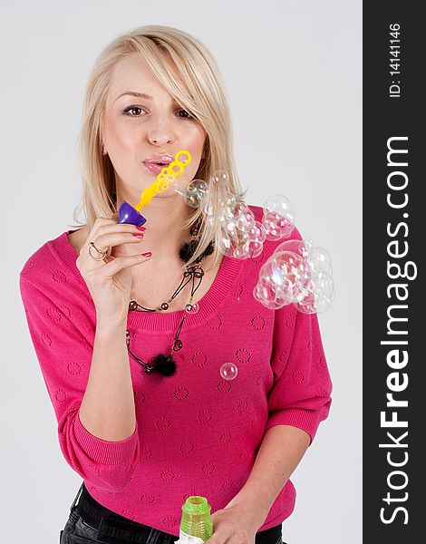 Blond woman blowing soap bubbles