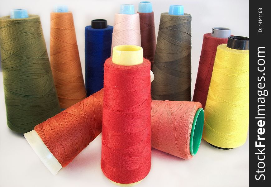 A group of eleven colored sewing threads