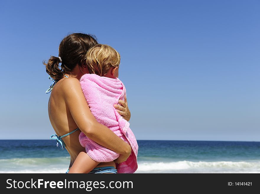 Summer vacation on the beach: mother carrying her daughter. Summer vacation on the beach: mother carrying her daughter